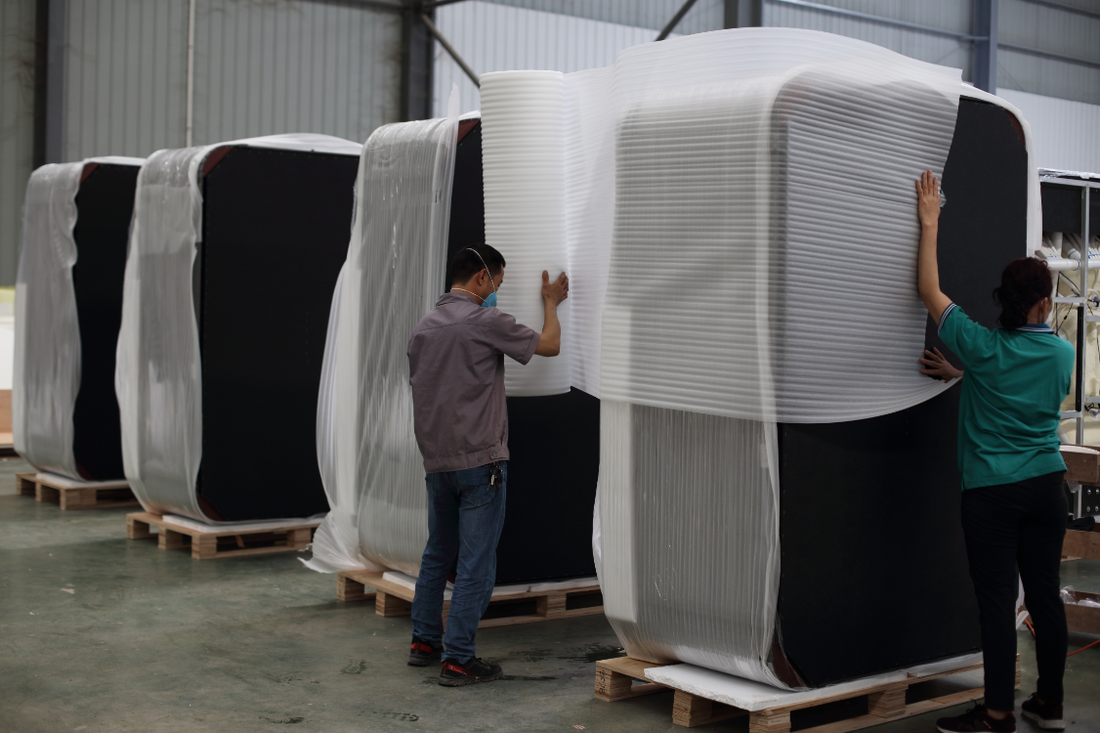 Valora factory team applying protective foam wrap to finished hot tubs before shipping