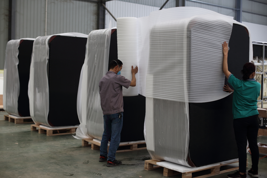 Valora factory team applying protective foam wrap to finished hot tubs before shipping