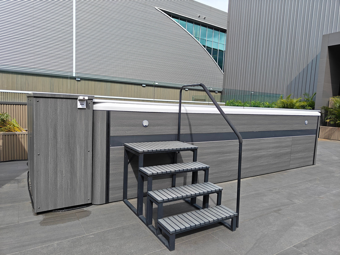 Valora outdoor showroom swim spa with four-step entry stairs and handrails on both sides