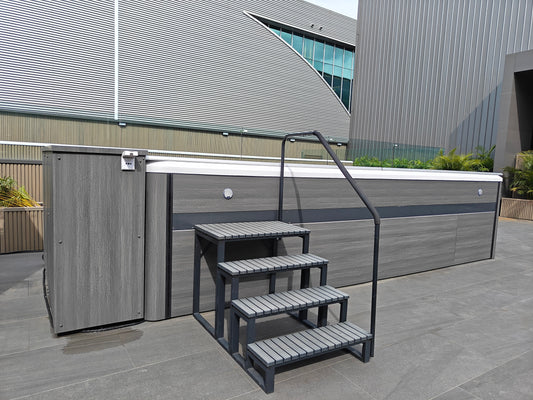 Valora outdoor showroom swim spa with four-step entry stairs and handrails on both sides
