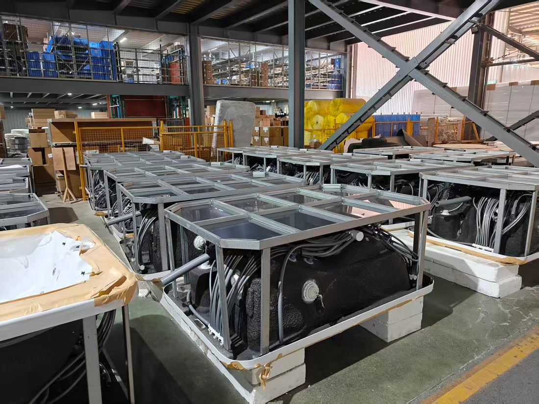 Hot tub shells positioned upside down in the Valora factory with frames and plumbing visible during production